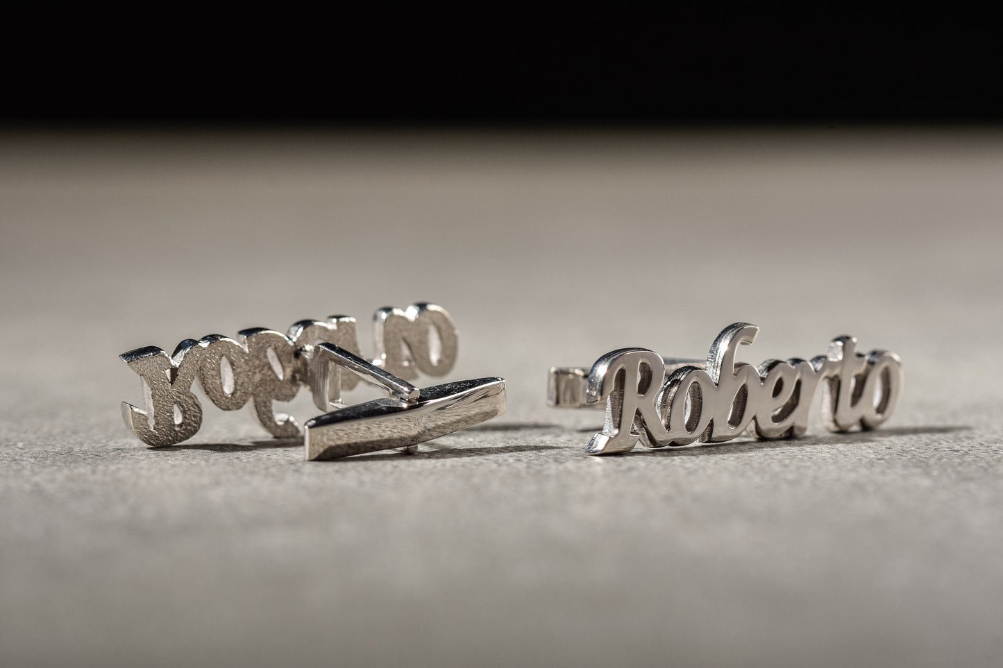 Close up of elegant cursive name cufflinks in 18k gold plated finish