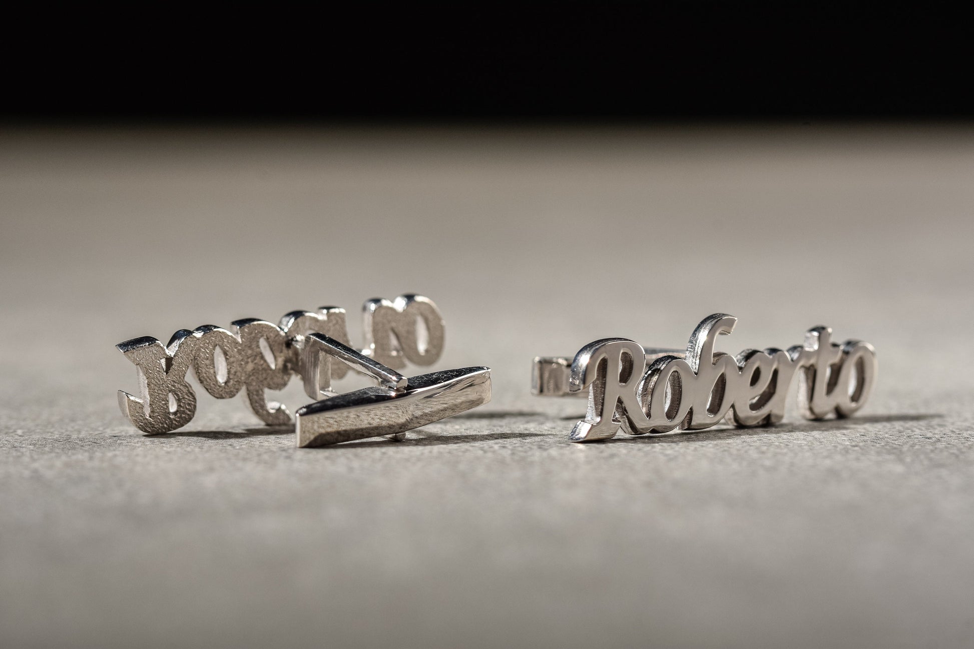 Close up of elegant cursive name cufflinks in 18k gold plated finish