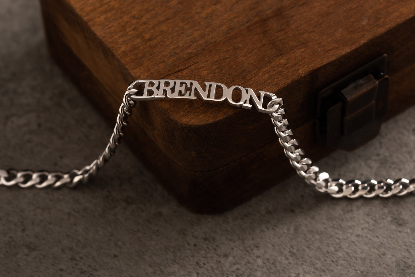 Close up of custom name engraving on a silver men's cuff bracelet