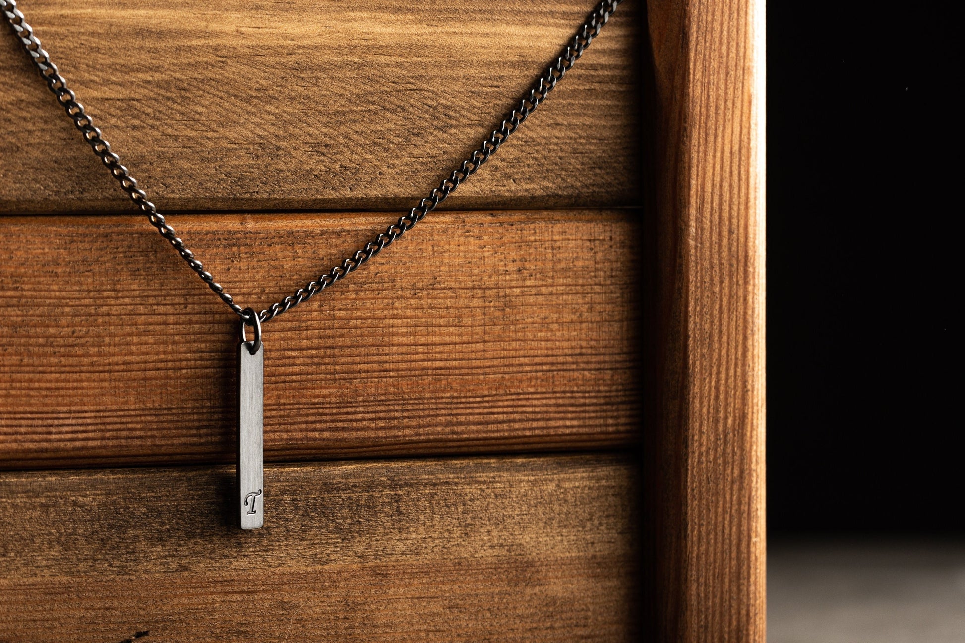 Close up of precision laser name engraving on a 925 silver bar pendant