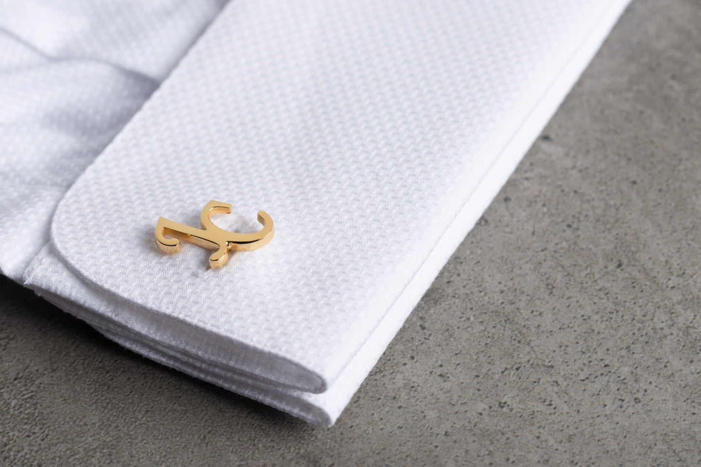 Close up of personalized interlocking monogram cufflinks in 18k gold finish