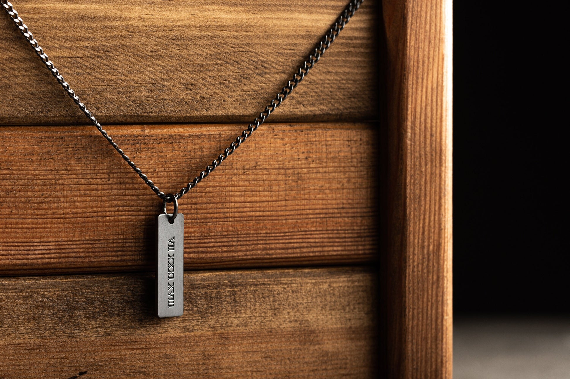 Detailed laser name engraving on a sterling silver bar pendant