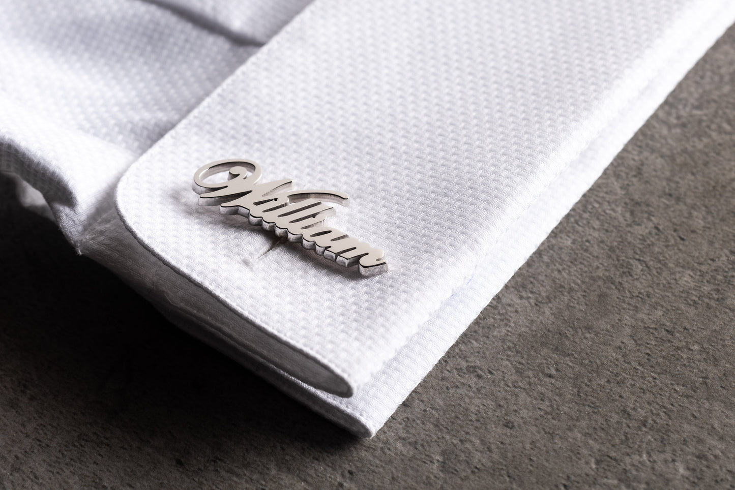 Close up of personalized 18k gold plated name cufflinks in script font