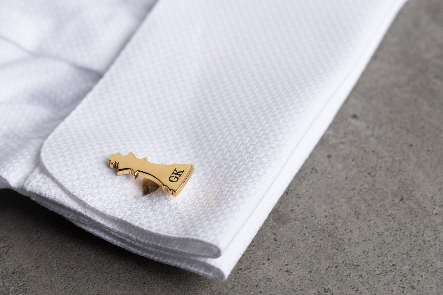 Close up of personalized 18k gold plated chess cufflinks with engraved initials