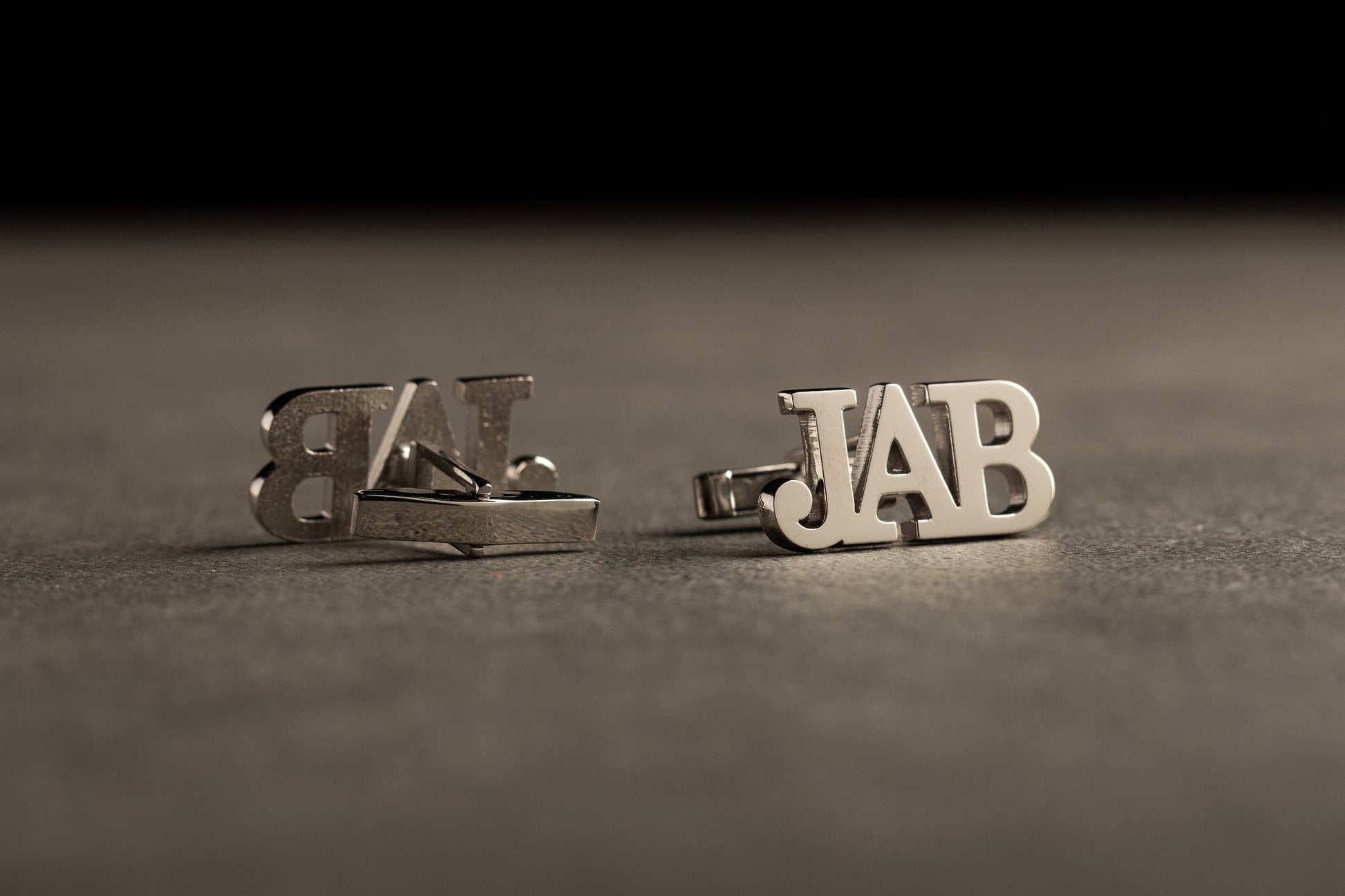 Close up of custom engraved initials on 18k gold plated cufflinks
