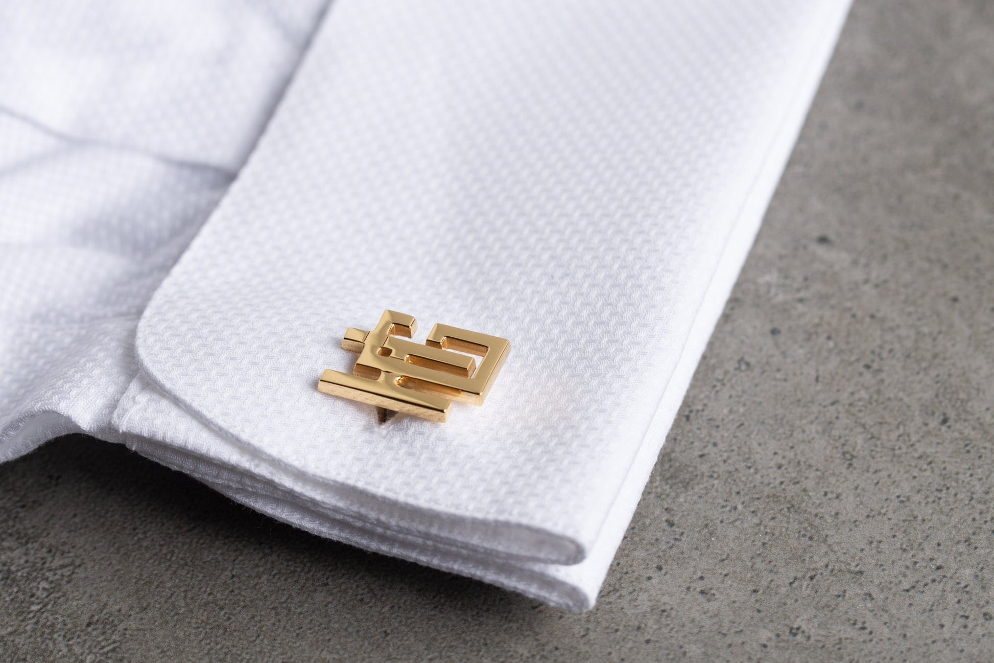 Close up of engraved initial cufflinks in gold and silver finishes