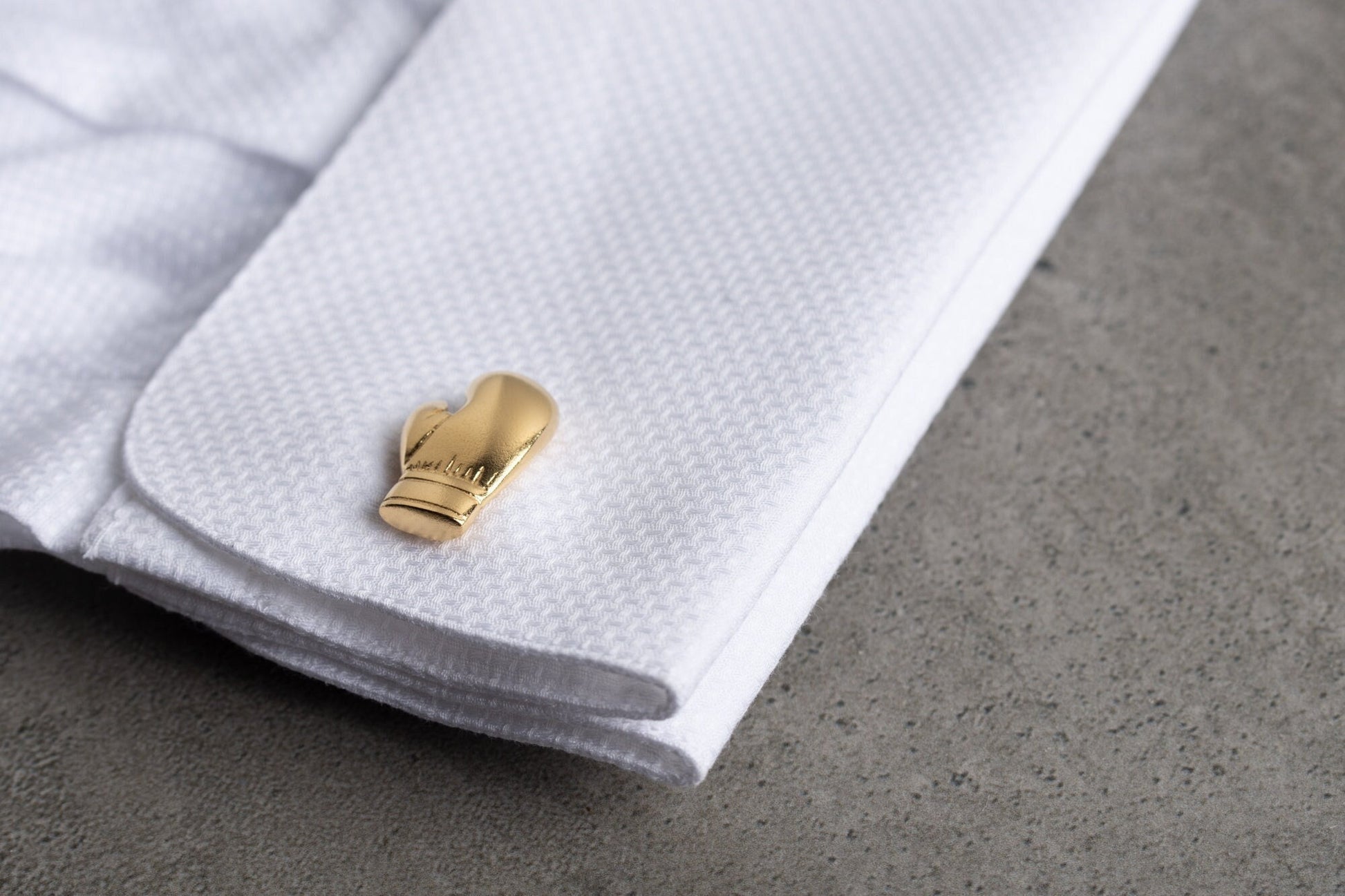 Close up of personalized boxing glove cufflinks in 18k gold finish